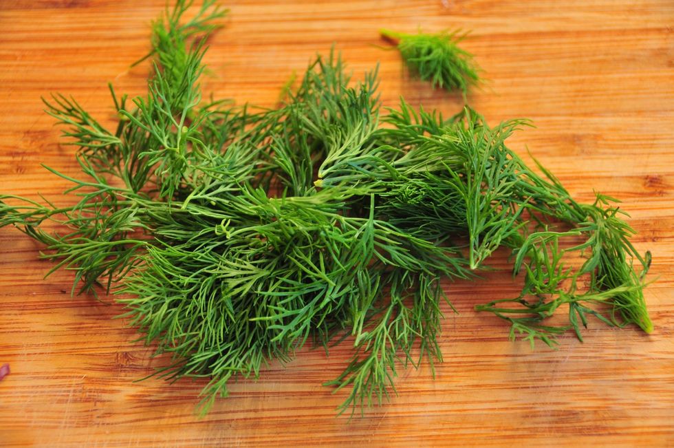 Remove the dill leaves from the stem then place in a pile to chop.  If you roll all the dill into a tight bunch it makes it really easy to chop.  Add to the bowl.