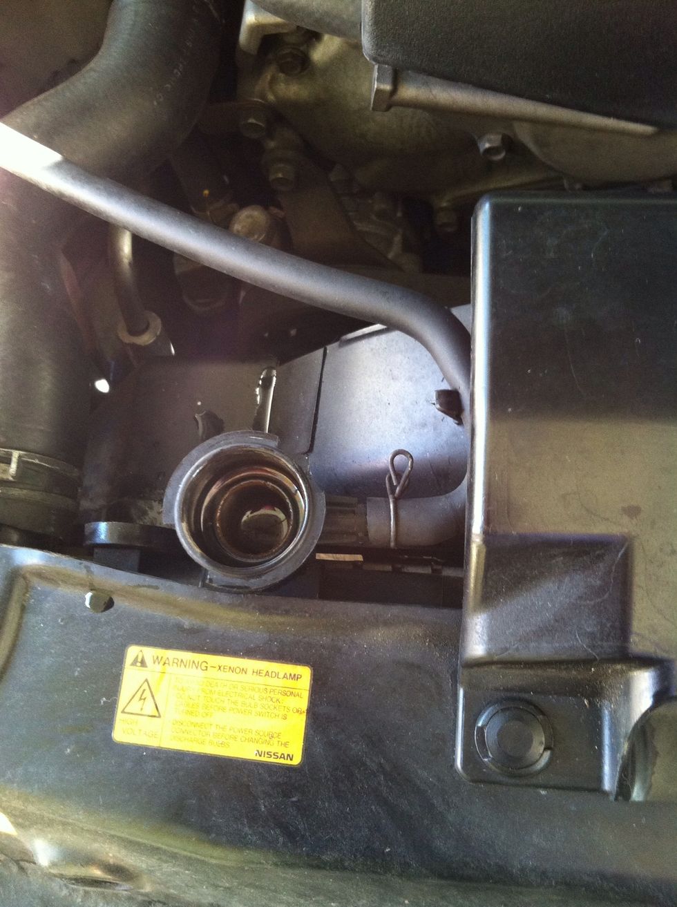 Remove the hose that is attach between the radiator and the coolant container.
