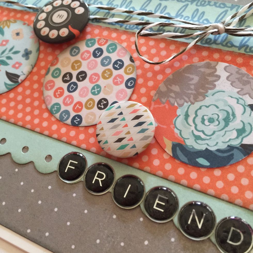 Remove the letters FRIEND from the epoxy alpha sticker sheet and adhere to the card on the right side of the scallops.