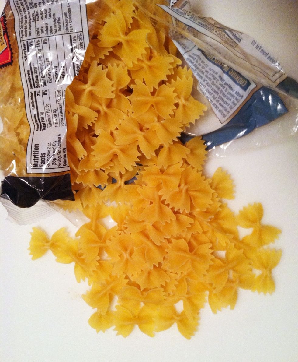 Remove the onion and add the pasta to the boiling water.  This is bow-tie or farfalle pasta. When cooked, strain the pasta and place in a bowl.