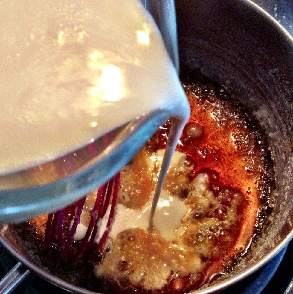 Remove the pan from heat & slowly add heavy cream. Be very careful - the instant the cream hits the hot syrup, it boils up BIG. So add cream in slowly, whisking constantly.