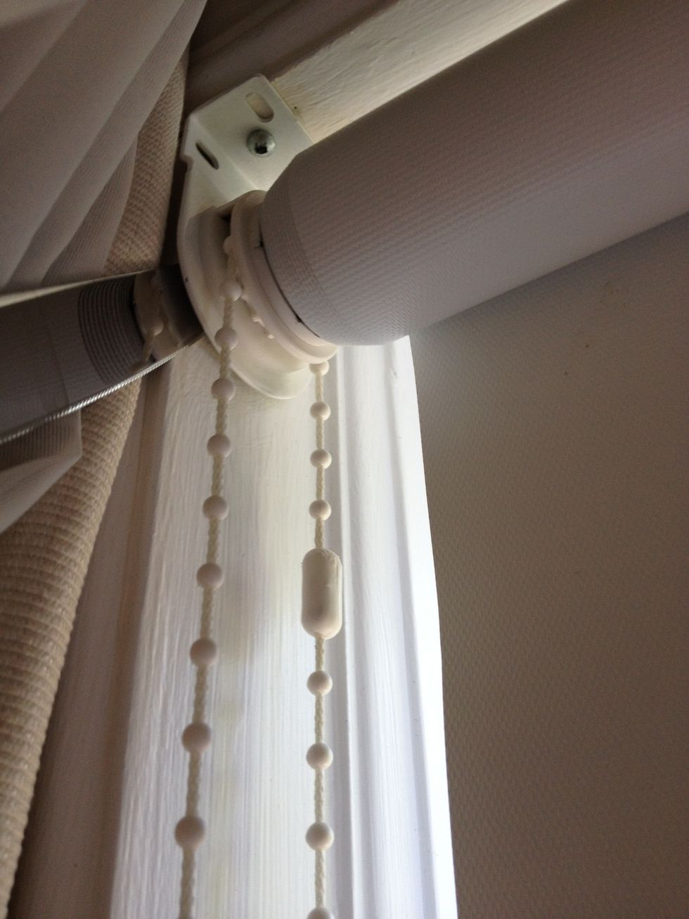 Remove the rolled up blind from the mounting hardware. I'm sliding a knife behind the bracket to release it. This is a Levelor blind and they can be removed in a SNAP! (they're 12 yrs old btw)