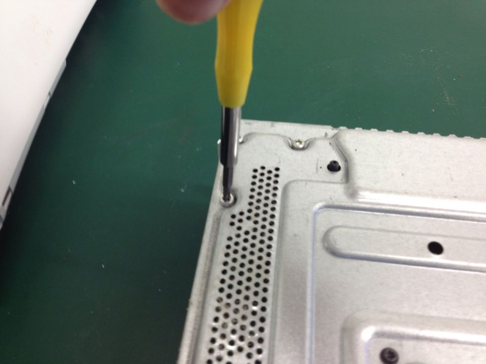 Remove the screws. 6 in total. 2 at each side and another two in the middle. They are silver and DO NOT HAVE ROUNDED HEADS.