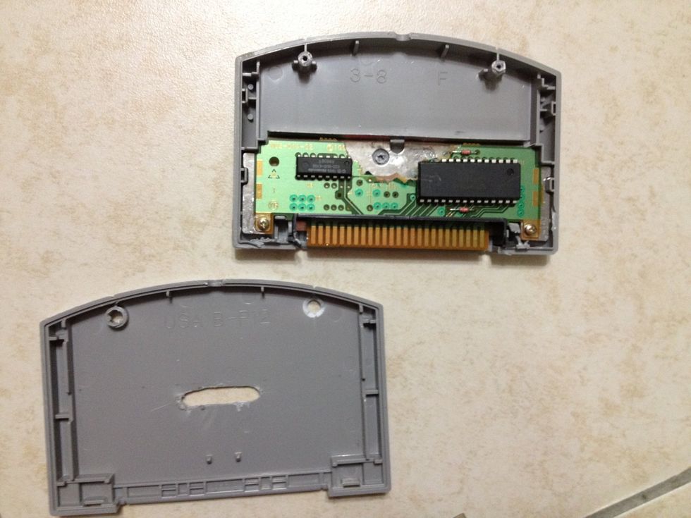 Remove the screws and open the game cartridge. If you don't have a screwdriver for the particular screw, don't worry. I didn't have one either. I just pried it open until it gave way.