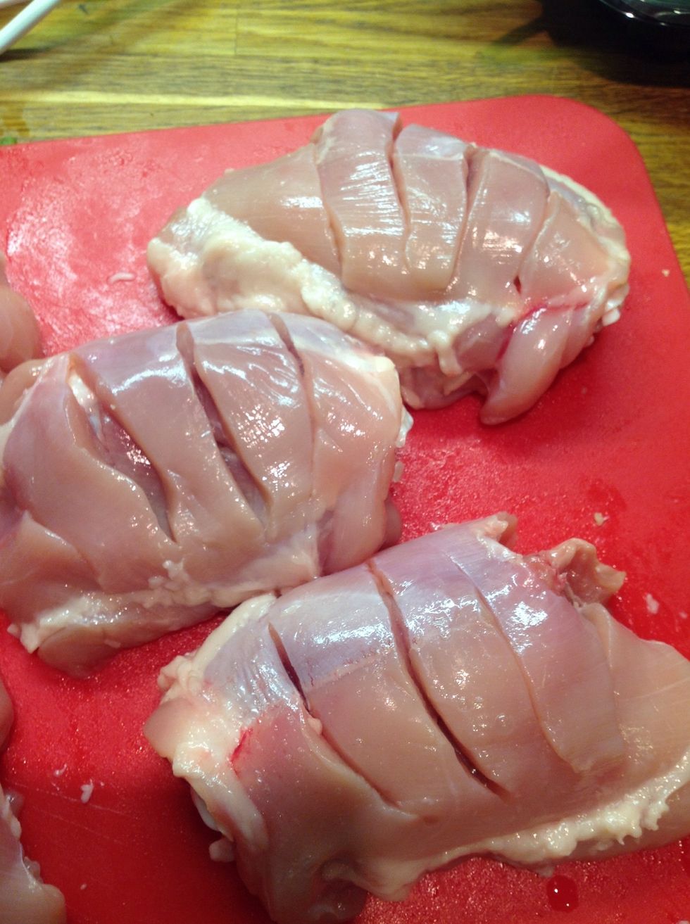 Remove the skin and make deep slices across the chicken breasts.
