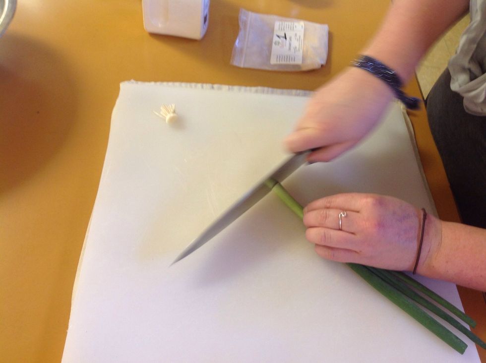 Remove the stem end from the scallion and begin slicing.