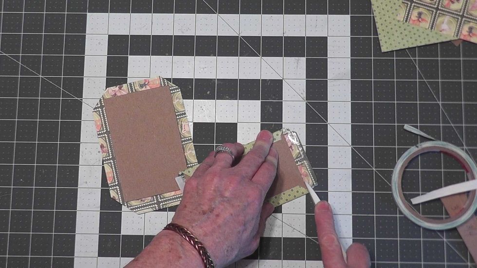 Remove the tape backing and attach the sides down on all four edges.  Use a bone folder to miter the corners to have a nice finished corners.