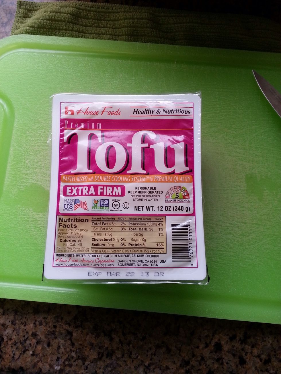 Remove the tofu from the package.  Place on a dish and put something heavy on it (I used a plate).  This will push out the excess liquid from the tofu.