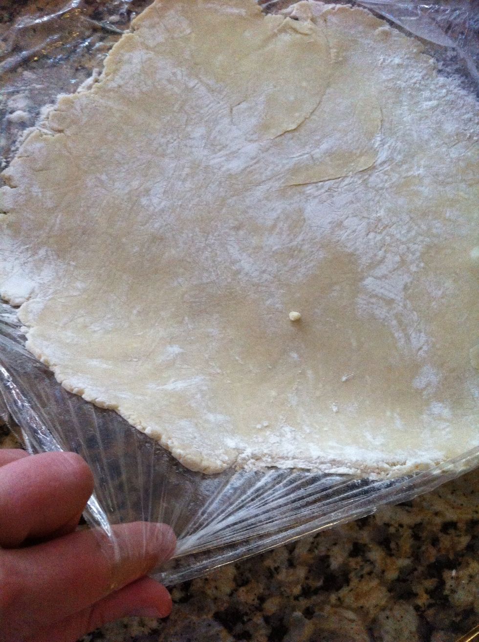 Remove the top layer of wrap, and pick the bottom up so that you can flip over your hand to move to pie dish