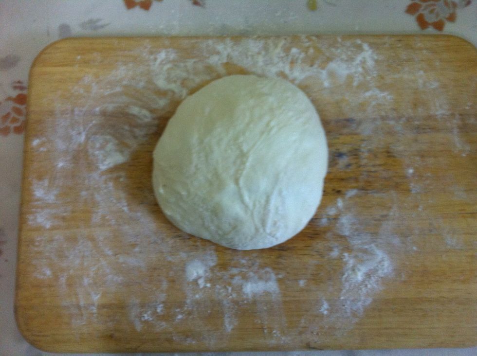 Remove the towel and shape your dough into a ball by tucking in the sides under the base. Apply flour in your hands, it's a really sticky dough
