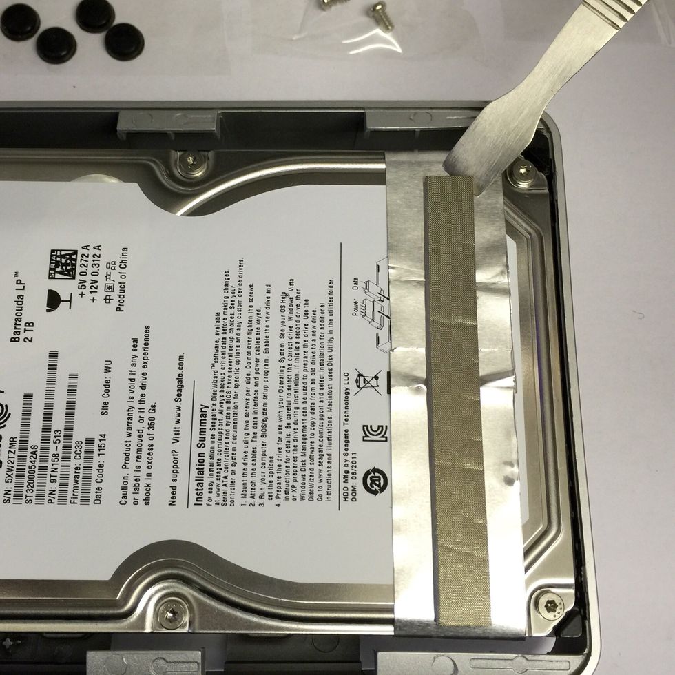 Remove this padded strip. Gently push the spudger into the end and lift away. Put a piece of sellotape down in your piece of paper the the strip on top.