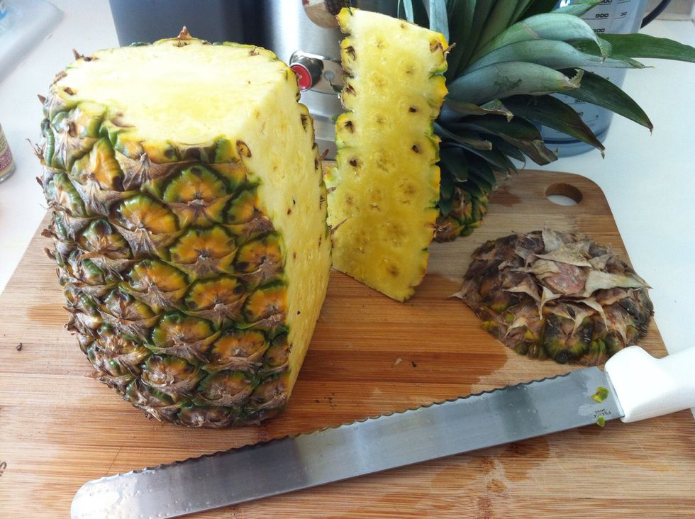 Remove top and bottom of pineapple to have it seat securely on the cutting board.