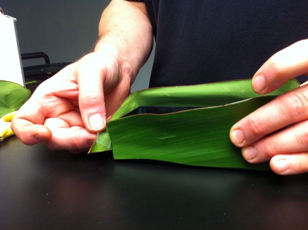 Remove UGLU dash backings and wrap one half of the ti leaf around container. Press against UGLU to secure.