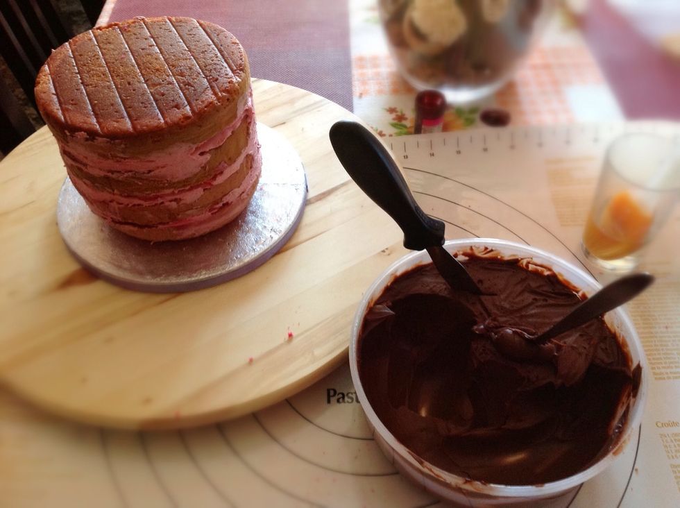 Repartimos con la esp\u00e1tula lo que all\u00e1 sobresalido y empezamos a cubrir con ganache.