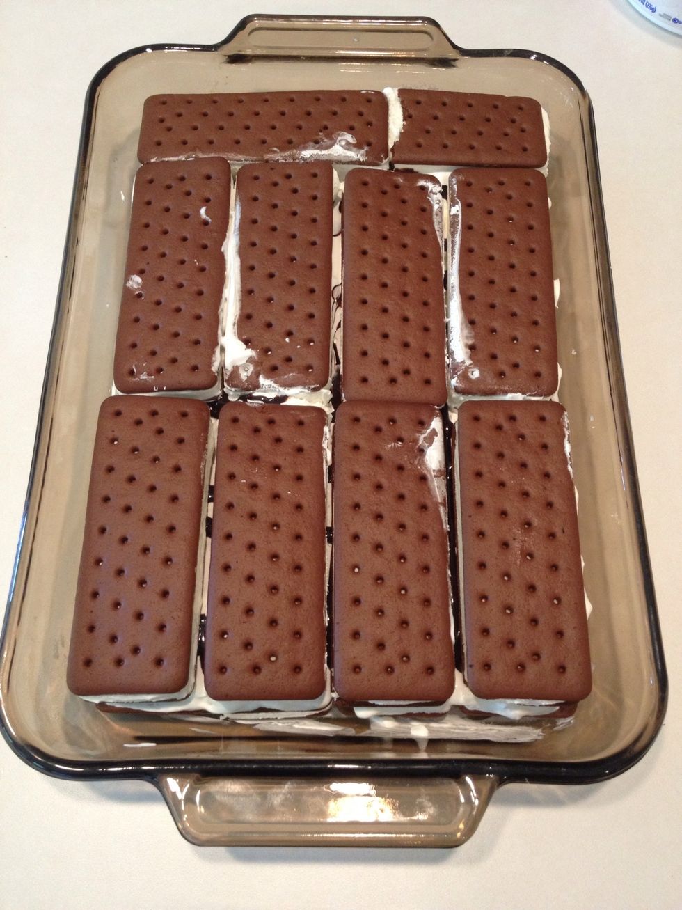 Repeat steps again to make 2nd layer. Unwrap and place ice cream sandwiches on chocolate syrup.