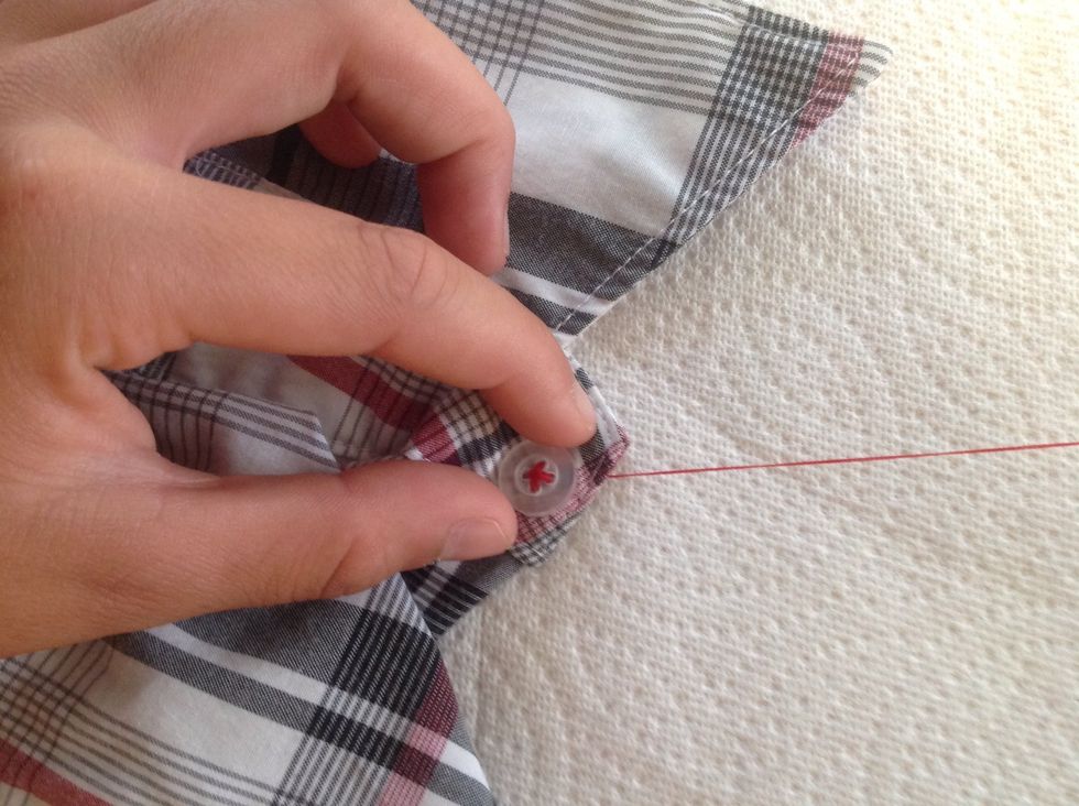 Repeat the in-and-out needle and thread "X" steps two more rotations, until the button is secure.