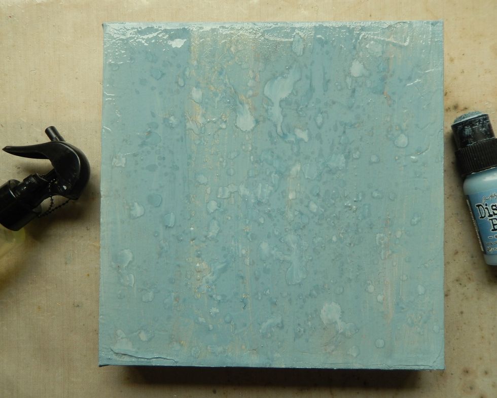 Repeat the process using the Stormy Sky Distress Paint, applying fewer drips of water and drying some parts again with your heat gun.