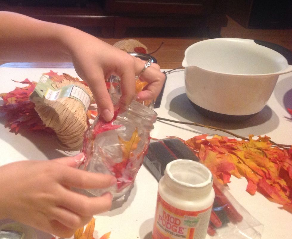 Repeat the step of placing and covering the leaves until the jar is covered.
