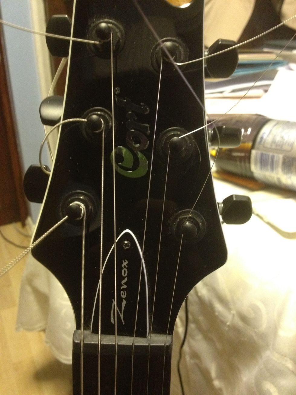 Repeat these steps over all of the strings. Double check the bottom and ensure the stings go through the notches at the bottom, if not just unwind it, pull it on and wind it back up to tune