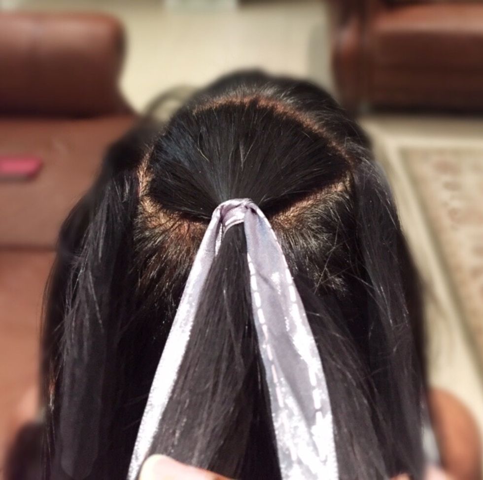 Repeat this on the left side. Take the left section of the hair and cross it over the middle section. Add a small amount of hair to your new left section.
