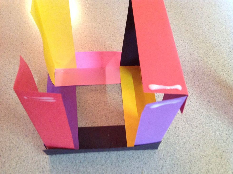 Repeat this step, adding a bit more glue to the tops of the new pieces of paper. This is creating the top of your box. You may have the hold the paper for a bit until the glue dries.