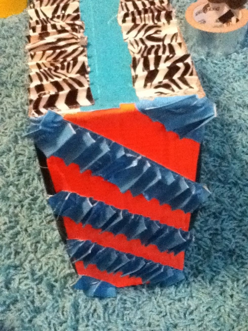 Repeat this step as needed. Or until most of the box is covered. Add the string or rope at the top of the box and tape it down so it won't come off.