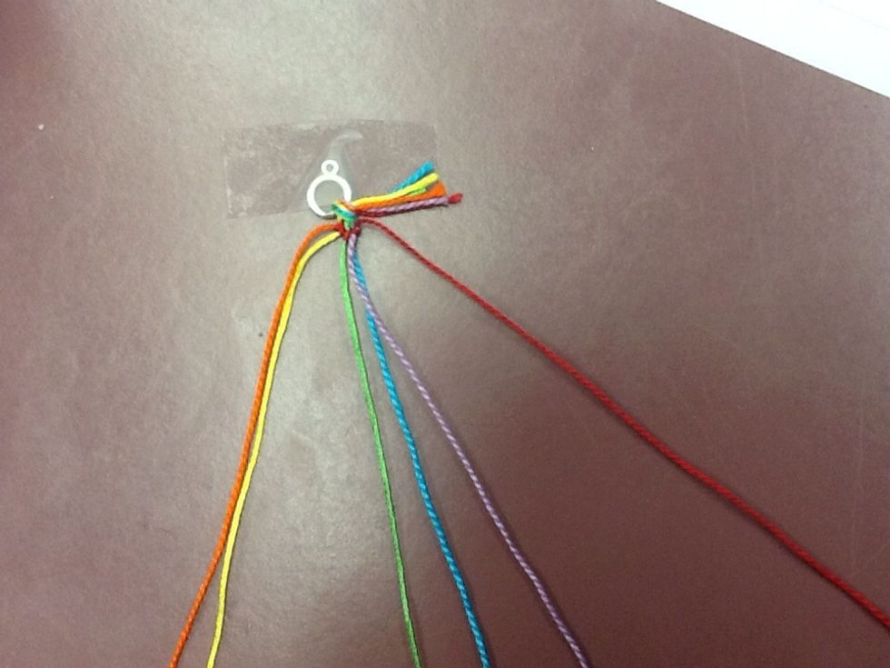 Repeat this step knotting the red string over the other colours (yellow, green, blue, and purple) until the red string is all the way to the right.