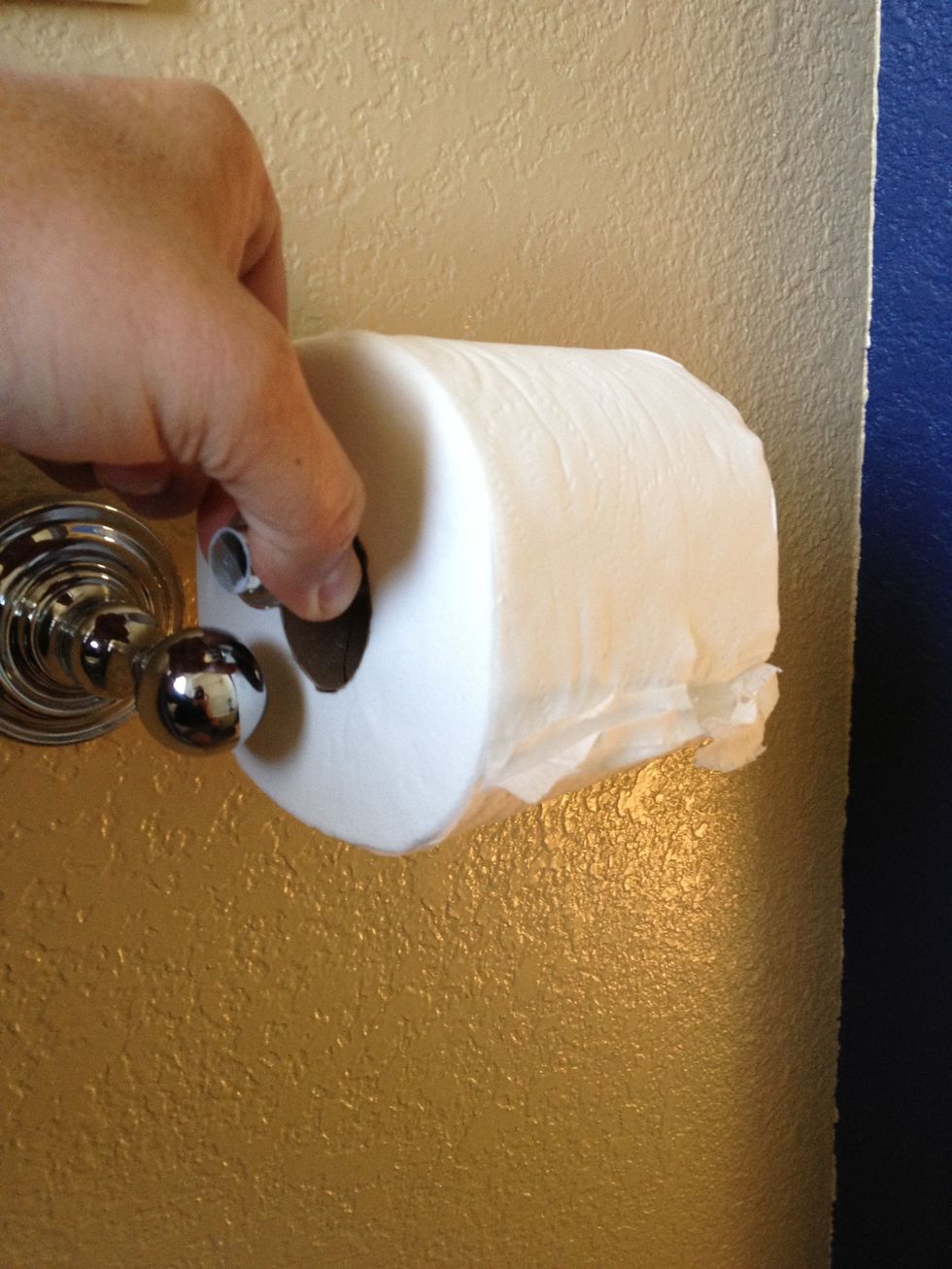 Replace spindle with new roll of toilette paper on mounts.