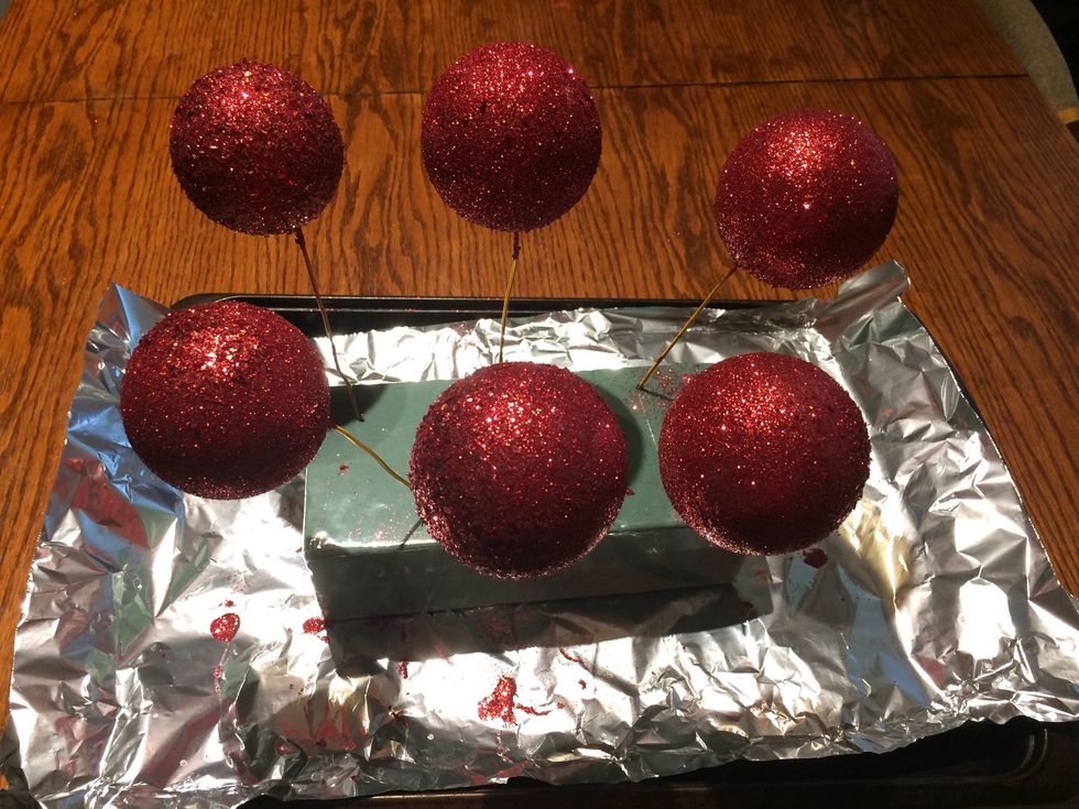 Rest the glittered balls back in the foam block.