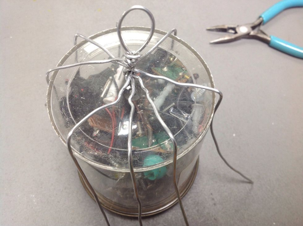 Rest the wires on top with the handle facing up, and bend the radiating wires down the side of the cylinder.