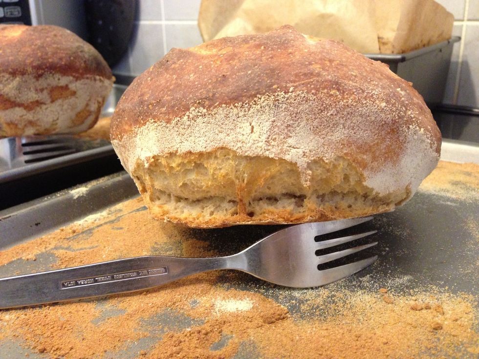 Resting the loaf on a fork can help moisture forming on the bottom and making it soggy.