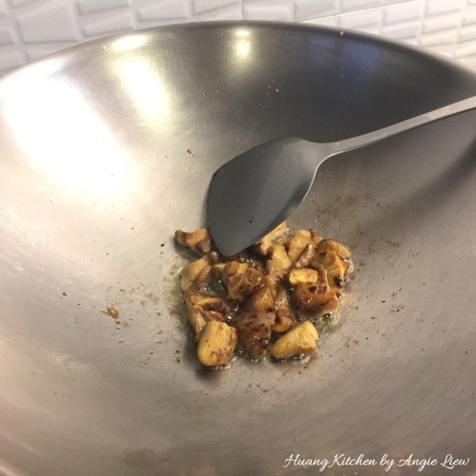 Retain 1 tbsp oil in wok, add in cut mushroom caps.