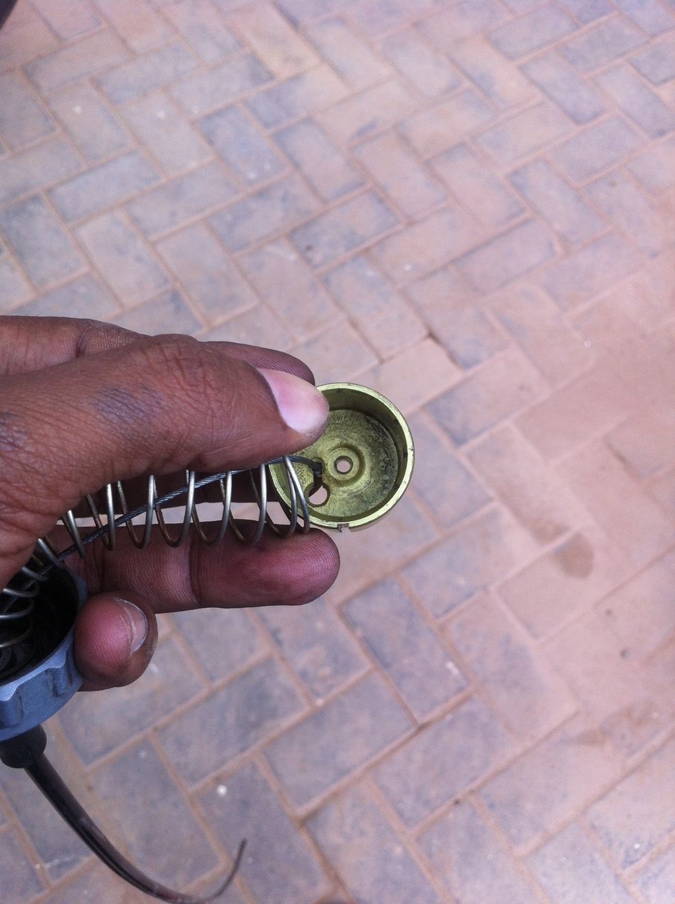 Retract the spring back to make room for pushing the cable out of the locking slot.