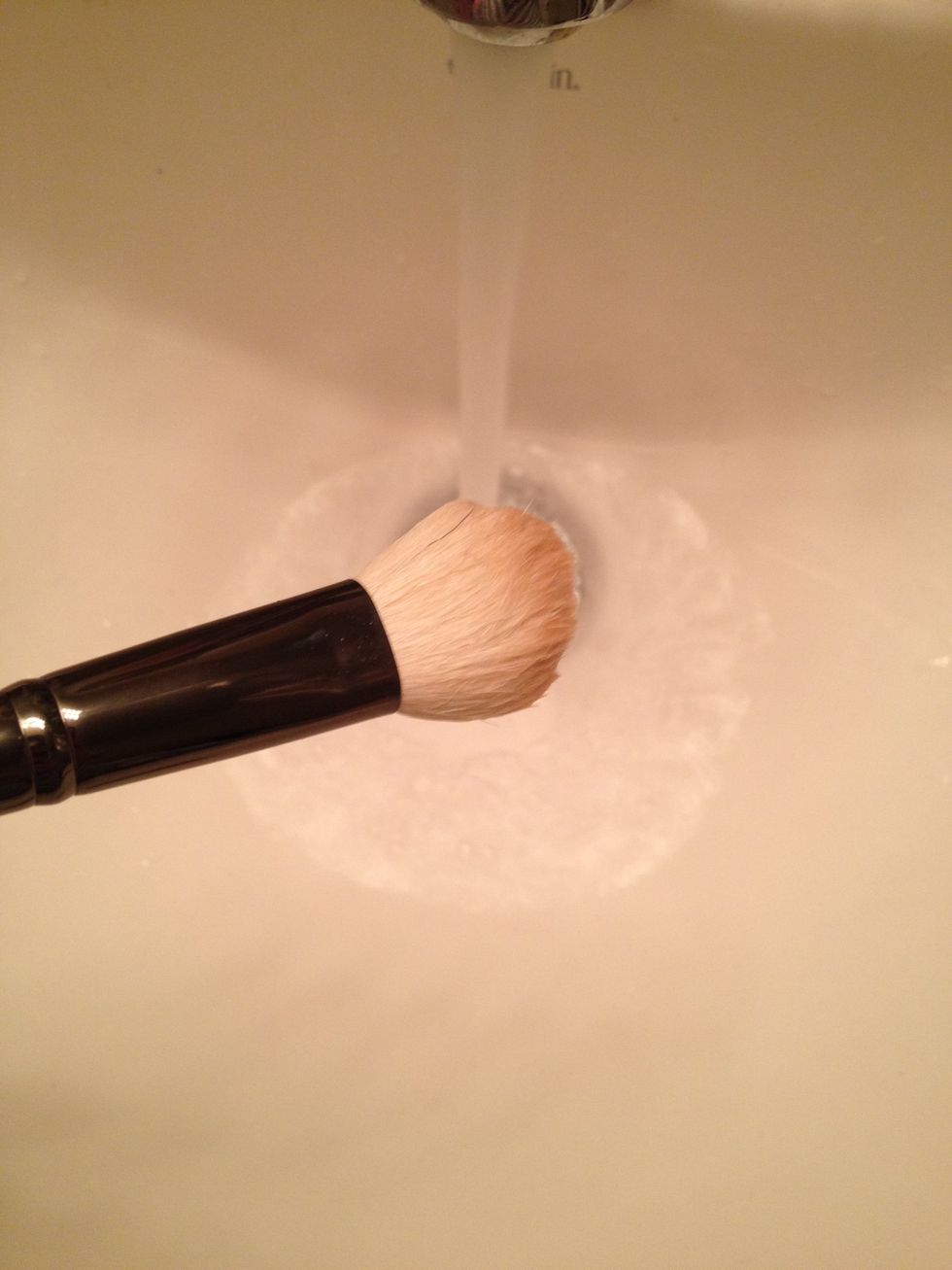 Rinse the makeup brush using lukewarm water.  Keep brush angled downward & rotate, making sure to saturate the brush hairs with clean water until all of the soap has been rinsed out.