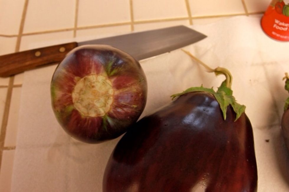 Rinse your eggplants clean and depending on the type of eggplants you have, you might have to cut the top off like so.