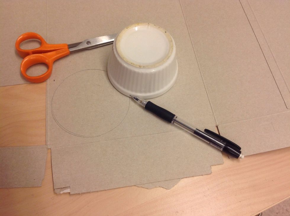 Rita av n\u00e5got runt p\u00e5 kartong och klipp ut med papperssax.