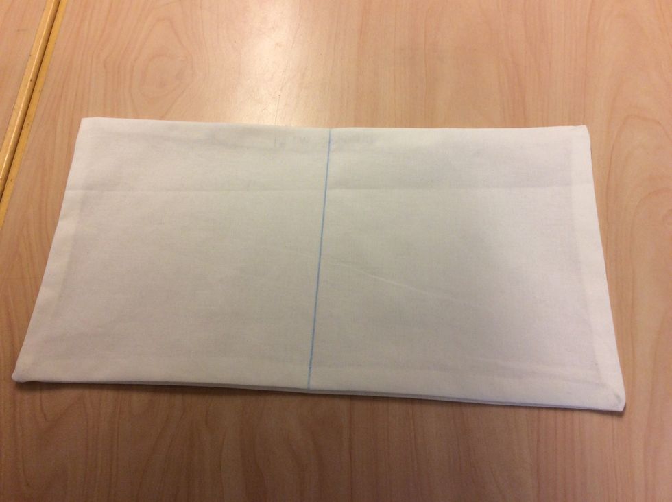 Rita ut ett str\u00e4ck med tygpenna mitt p\u00e5 innerkudden.