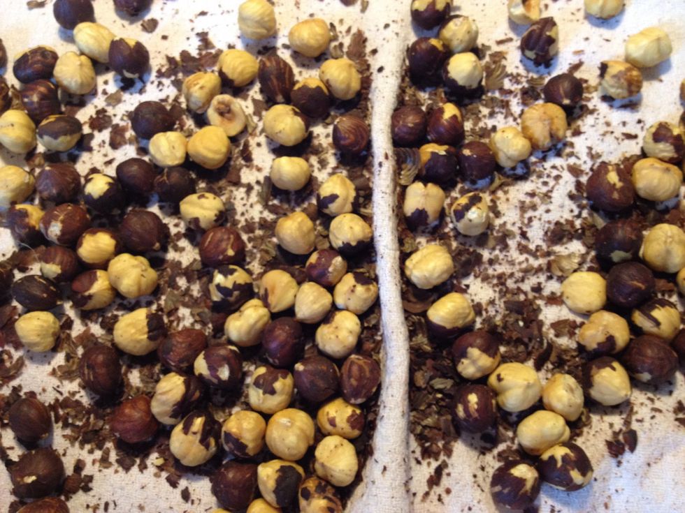 Roast the hazelnuts in the oven for 10-15 minutes. Stir occasionally. Rub the hazelnuts in a the-towel to get the brown "skin" off.