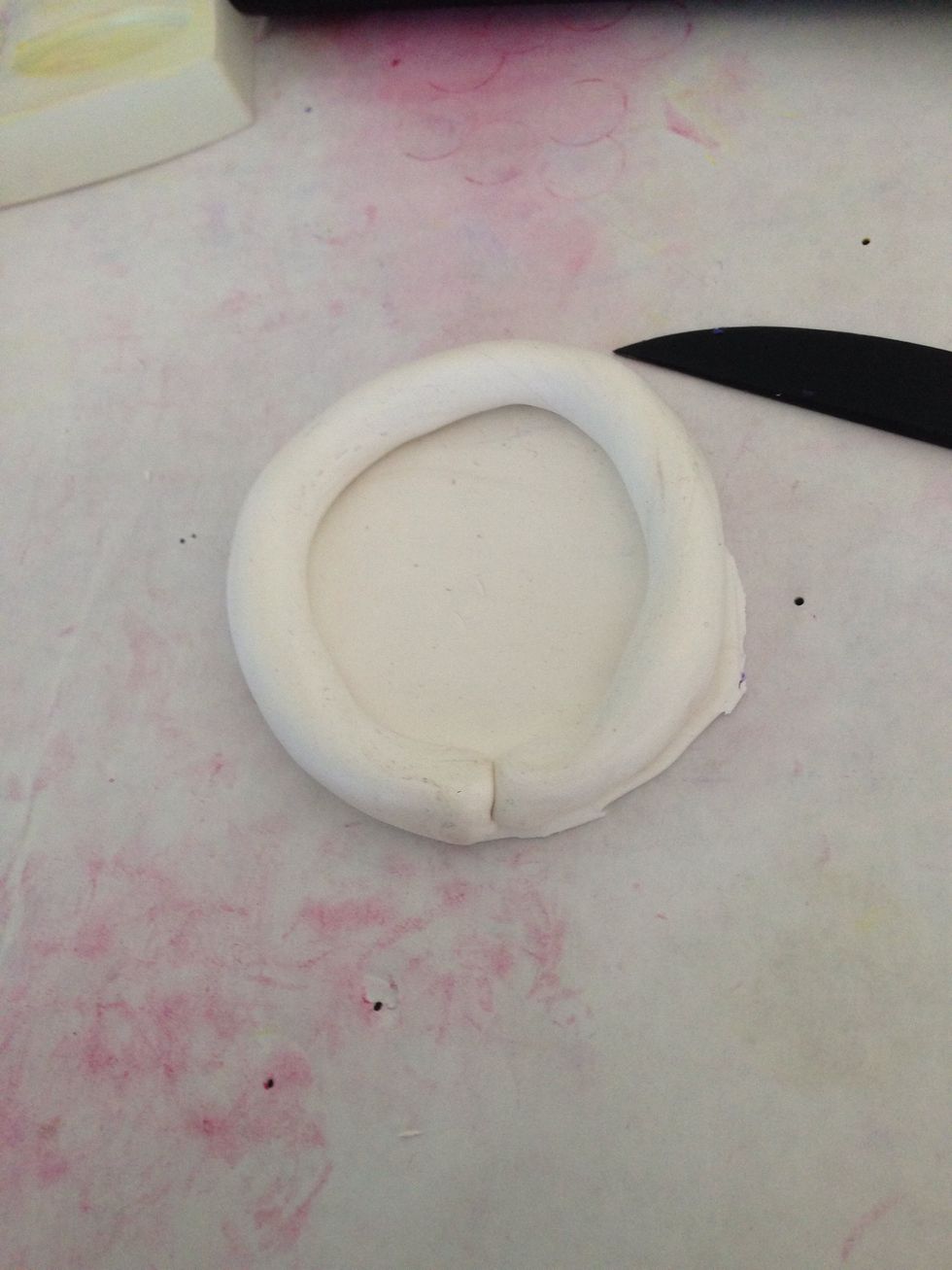 Roll a piece of clay into a "snake" and place on the border of the circle.