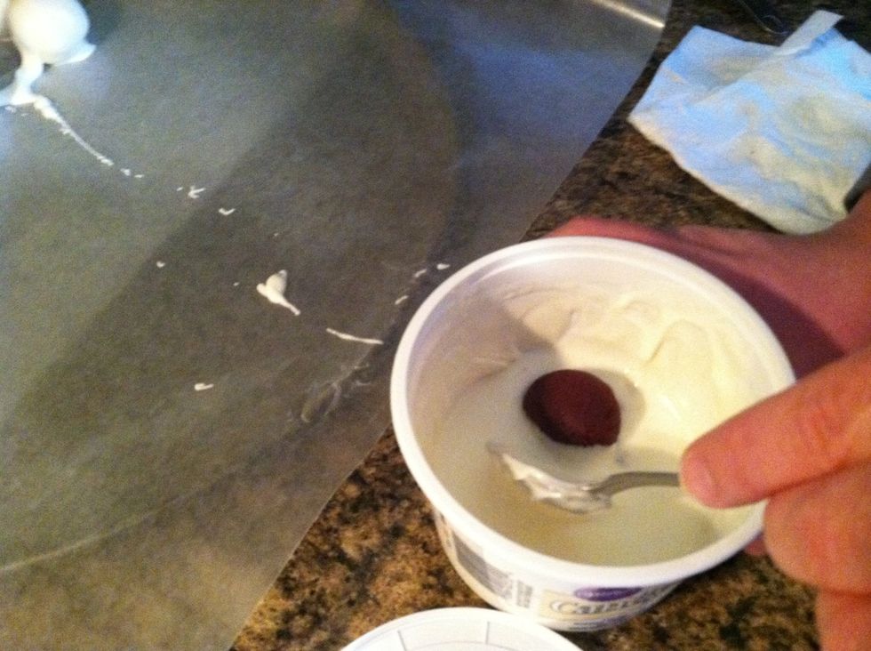 Roll balls with spoon for even coverage. Can use 2 forks-whichever your preference. Then place on covered cookie sheet.