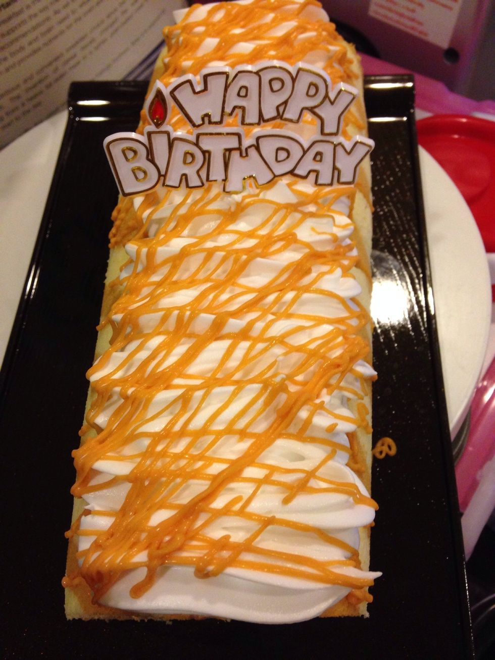 Roll cake and then decorate with whiping cream and thai tea sauce