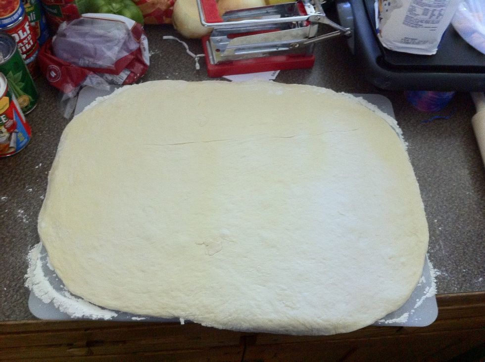Roll dough out to desired consistency. I am using a square cookie sheet for my pizza. this recipe makes ALOT of pizza dough. Prepare pan with cooking spray and a sprinkling of cornmeal