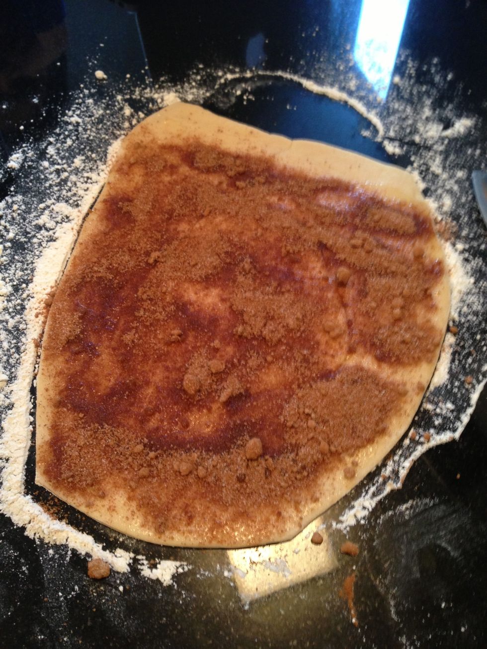 Roll dough roughly 12" wide and 1/2" thick. Spread melted butter everywhere except one inch of one side. Sprinkle cinnamon sugar mixture over the same