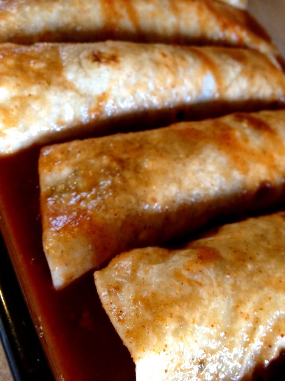 Roll each filled tortilla and put in the pan. I sprayed the pan with cooking spray and put a little sauce on the bottom first. After all enchiladas are finished pour the sauce over the top.