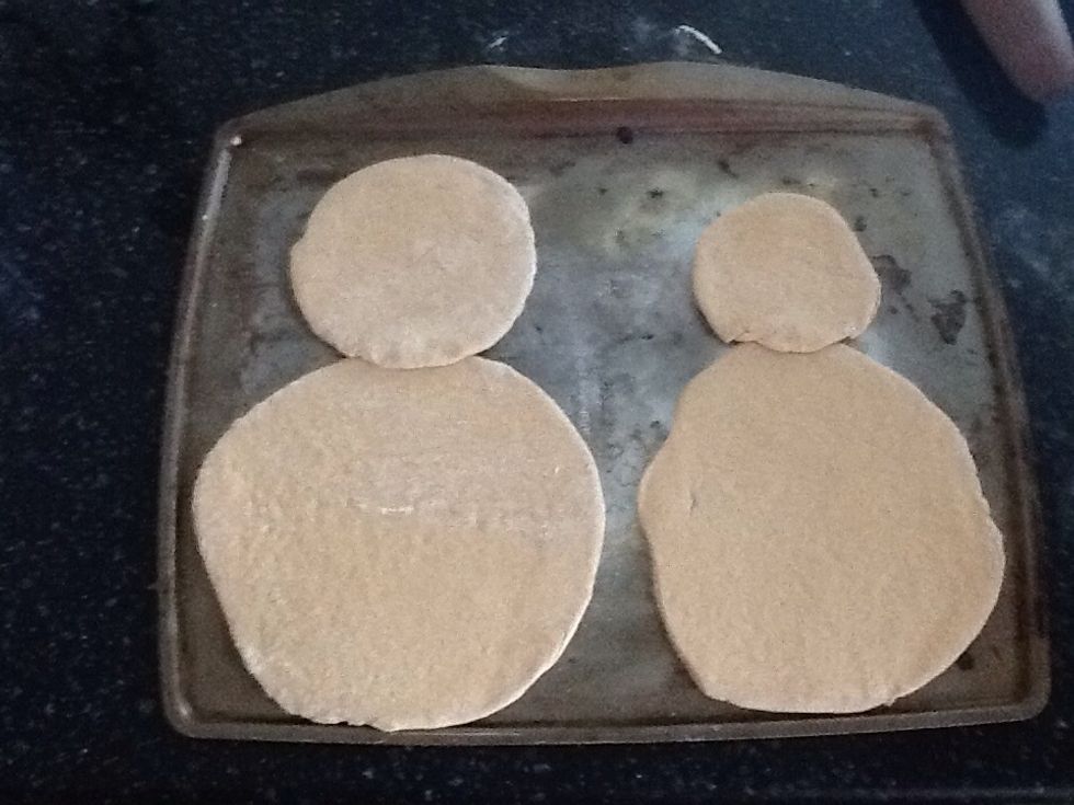 Roll each piece into a circle approximately 1/4 inch thick, and place on a large baking sheet, one large piece for each body and one small piece for each head. Brush each crust lightly with olive oil.