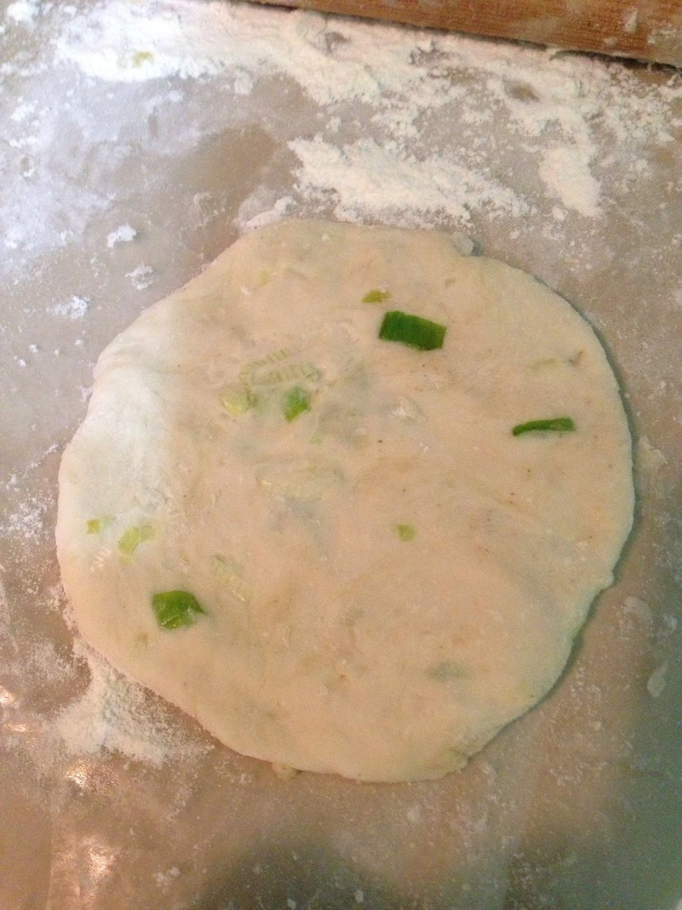 roll it and form into a flat circle like previously. This is so that the scallion will blend into the dough like this