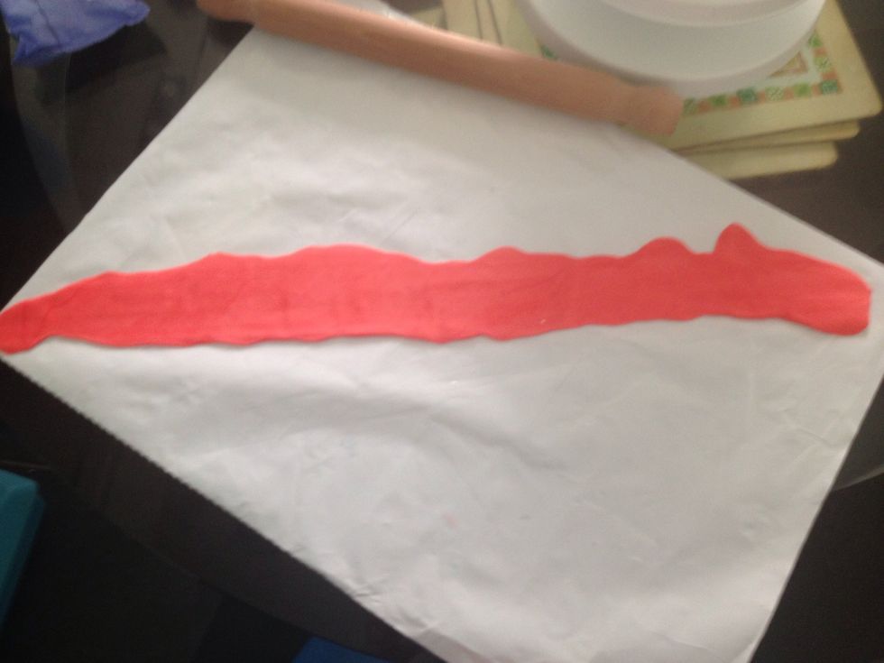 Roll out a long strip of red icing