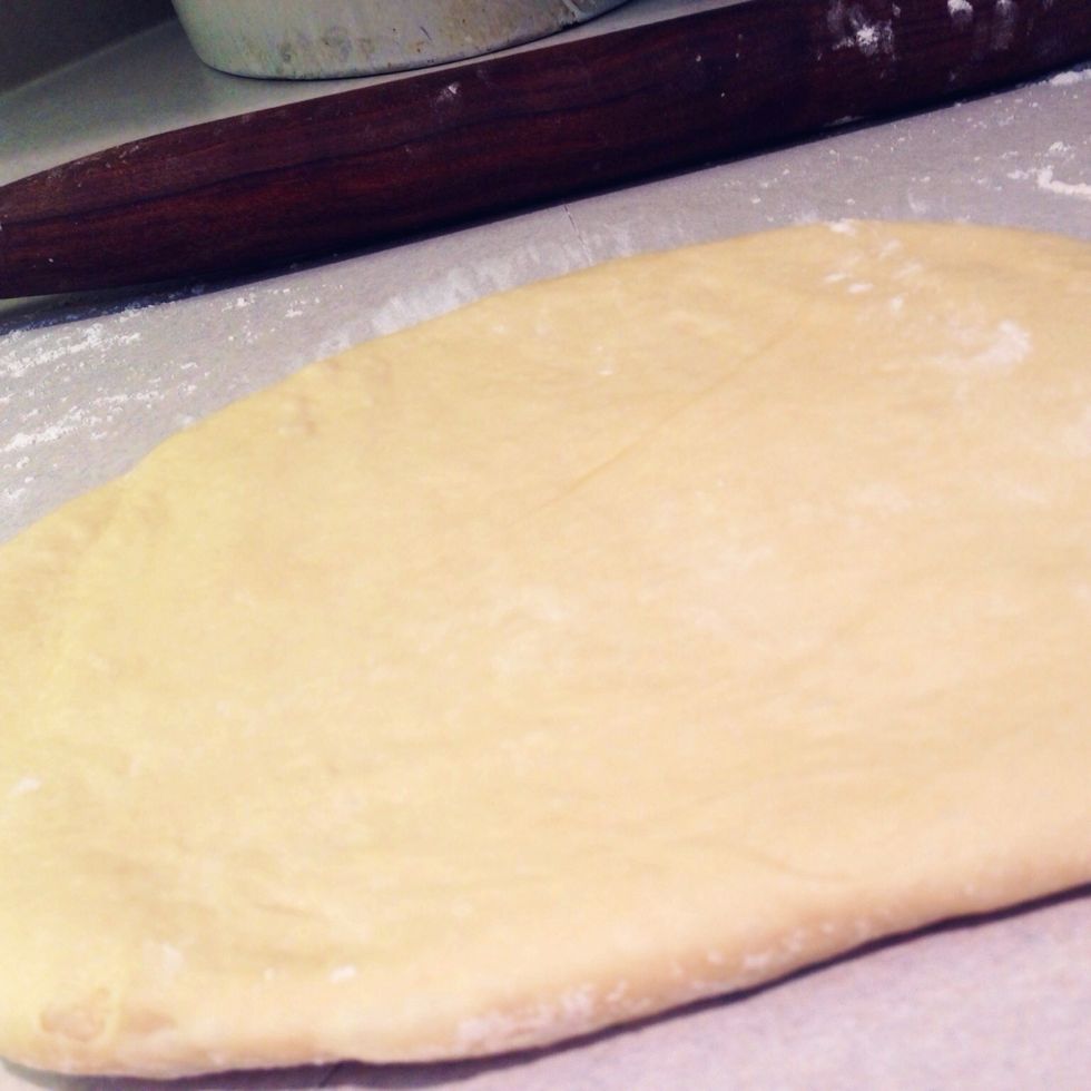 Roll out one half of the dough on a lightly floured surface until it is approximately 20 by 13 inches.