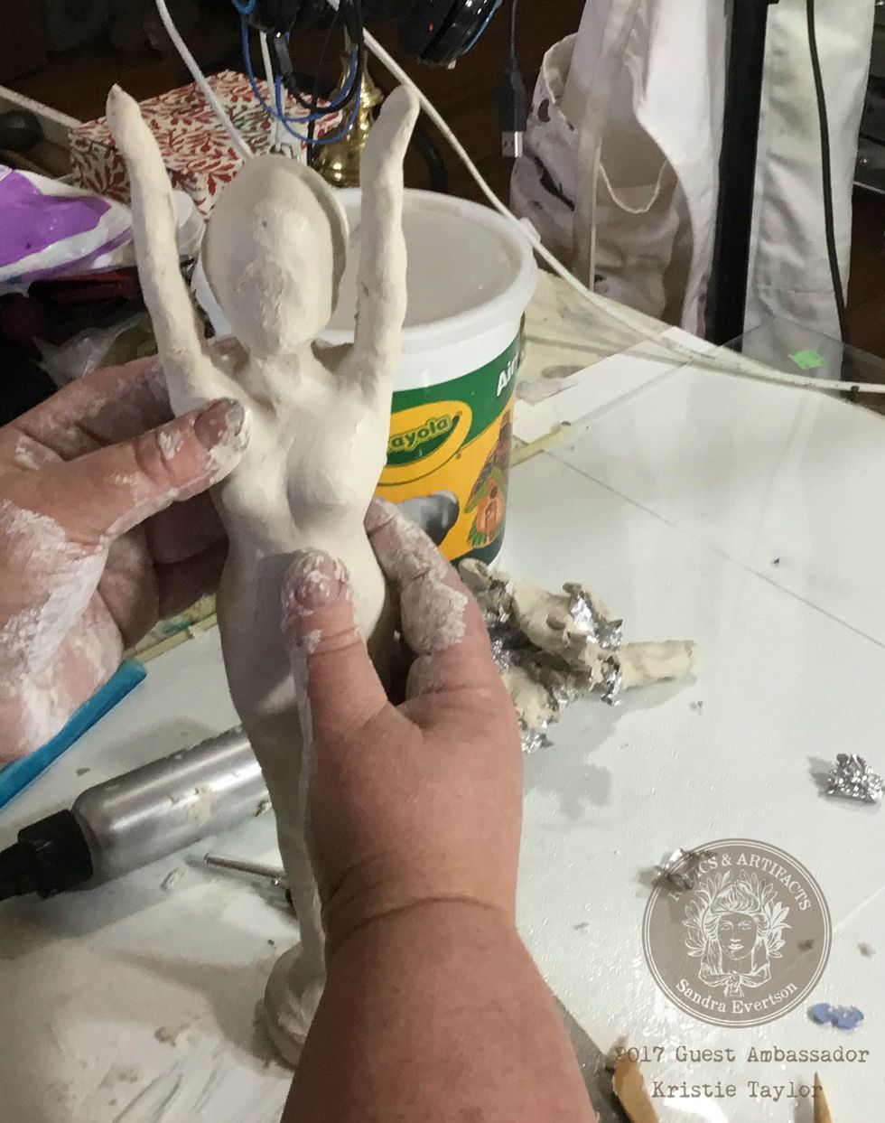 Roll out some paper clay and start applying it to the doll. I used my fingers, some water, and several sculpting tools to smooth and shape the clay.
