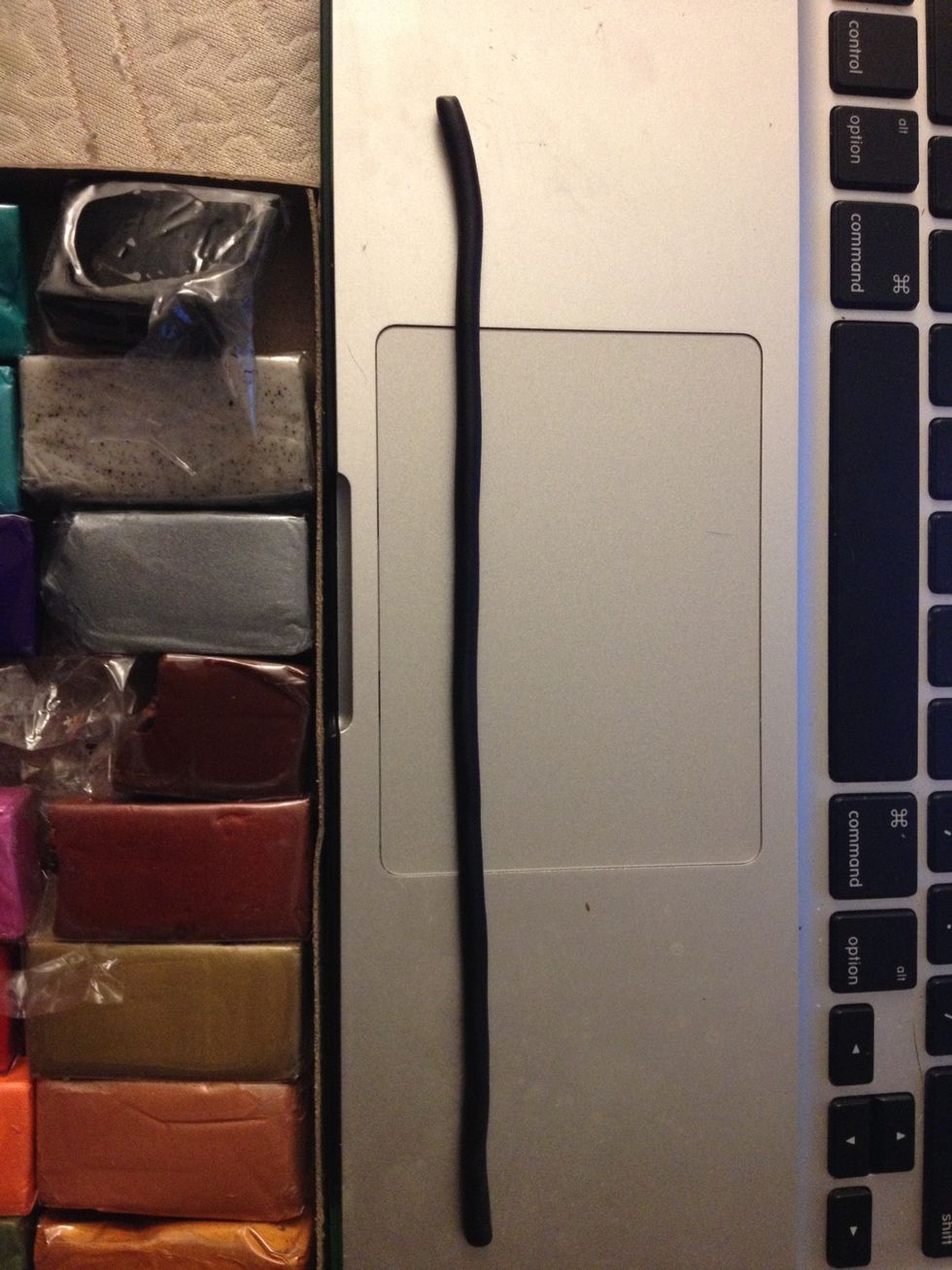 Roll out the black ball into a long, thin cylinder. Thin enough to look like glasses, but thick enough to be sturdy.